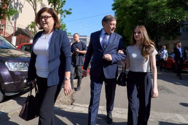 Bükreş, Romanya. 4 Mayıs 2025: Romanya 2025 cumhurbaşkanlığı seçimlerinde iktidardaki Avrupa yanlısı koalisyonun adayı Crin Antonescu (C), eşi Adina Valean (L) ve kızı Irina (R) ilk turda oylarını kullandıktan sonra ayrıldılar