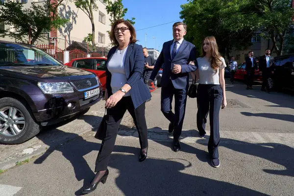 Bükreş, Romanya. 4 Mayıs 2025: Romanya 2025 cumhurbaşkanlığı seçimlerinde iktidardaki Avrupa yanlısı koalisyonun adayı Crin Antonescu (C), eşi Adina Valean (L) ve kızı Irina (R) ilk turda oylarını kullandıktan sonra ayrıldılar