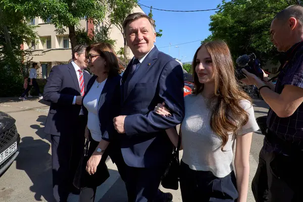 Bükreş, Romanya. 4 Mayıs 2025: Romanya 2025 cumhurbaşkanlığı seçimlerinde iktidardaki Avrupa yanlısı koalisyonun adayı Crin Antonescu (C), eşi Adina Valean (L) ve kızı Irina (R) ilk turda oylarını kullandıktan sonra ayrıldılar