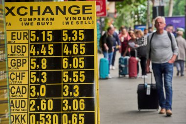 Bükreş, Romanya. 8 Mayıs 2025: Bükreş şehir merkezindeki döviz bürosunda, avro 5,35 ley 'e yükselirken gösteren döviz tahtasının önünden geçen insanlar görülüyor.