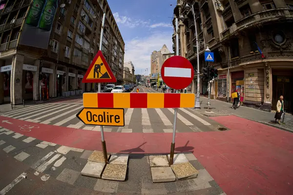 Bükreş, Romanya. 21 Mayıs 2025: Şu anda emlak müteahhidi AFI Europe 'a ait olan eski Bancorex binasında geniş çaplı yenileme çalışmalarının devam ettiği, Calea Victoriei şehir merkezindeki bir trafik şeridini yokuş yukarı kaydıran işaretler. 