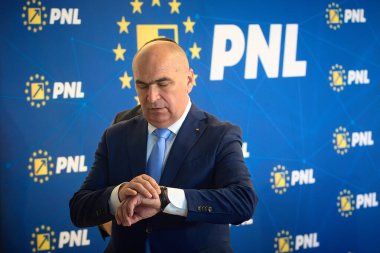 Bükreş, Romanya. 2 Haziran 2025: Ulusal Liberal Parti (PNL) geçici başkanı Ilie Bolojan, Ulusal Liberal Parti Ulusal Siyasi Bürosu toplantısının ardından düzenlediği basın toplantısı sonrasında nöbetini kontrol etti..