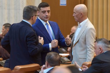 Bükreş, Romanya. 2 Haziran 2025: Romanya Milletvekilleri Meclisi 'nin genel kurul toplantısında Romenler Birliği (AUR) başkanı George Simion, Mihail Neamtu (L) ve Mugur Mihaescu (R) ile konuştu..