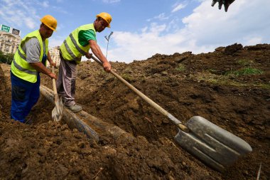 Bükreş, Romanya. 20 Haziran 2025: İşçiler Unirii Meydanı 'ndaki Dambovita Nehri' ni kaplayan beton levhanın yeniden inşa alanını kazıyorlar. Bu resim sadece editörler içindir..