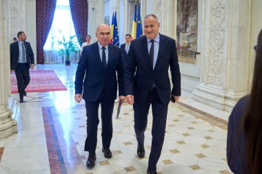 Bükreş, Romanya. 14 Temmuz 2025: Romanya Başbakanı Ilie Bolojan (L) ve Başbakan Yardımcısı Marian Neacsu (R), hükümet aleyhinde açılan gensoru önergesi üzerine düzenlenen ortak meclis toplantısına katıldılar.