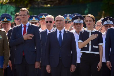 Bükreş, Romanya. 20 Temmuz 2025: Ionut Mosteanu (L), Romanya Savunma Bakanı Ilie Bolojan (C), Romanya Başbakanı ve Dışişleri Bakanı Oana Toiu (R), Bükreş 'teki Romanya Havacılık ve Hava Kuvvetleri Günü kutlamalarına katıldılar.