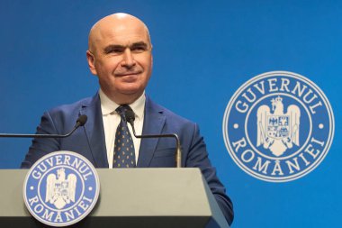 Bükreş, Romanya. 22 Temmuz 2025: Romanya Başbakanı Ilie Bolojan ve Dragos Anastasiu (resimde değil), Başbakan Yardımcısı, devlet şirketlerinin reformu hakkında Romanya Hükümeti Victoria Sarayı 'nda basın toplantısı düzenlediler.