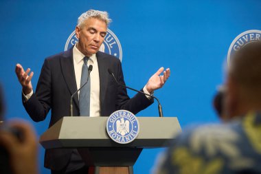 Bükreş, Romanya. 27 Temmuz 2025: Romanya Başbakan Yardımcısı Dragos Anastasiu, 20092017 yolsuzluk davasındaki tanık rolünü açıkladığı basın toplantısında istifasını açıkladı.