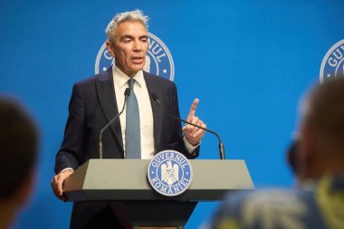 Bükreş, Romanya. 27 Temmuz 2025: Romanya Başbakan Yardımcısı Dragos Anastasiu, 20092017 yolsuzluk davasındaki tanık rolünü açıkladığı basın toplantısında istifasını açıkladı.