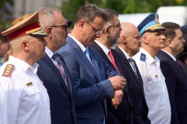 Bükreş, Romanya. 29 Temmuz 2025: Romanya Savunma Bakanı Ionut Mosteanu (C), Bükreş 'teki Ulusal Askeri Daire Sarayı önünde düzenlenen Romanya Ulusal Marş Günü kutlamaları sırasında saatini kontrol etti.