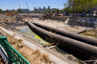 Bükreş, Romanya. 27 Ağustos 2025: Unirii Meydanı 'ndaki Dambovita Nehri' ni kaplayan beton levhanın yeniden inşa alanı. Yoğun bir şekilde parçalanan 350 metrelik beton levhanın 1934 'te kısmen onarılması gerekiyordu çünkü en ağır trafiği destekliyordu.
