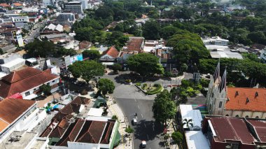 20 Eylül 2024 'te Malang, Endonezya' da, yemyeşil ağaçların arasına yerleşmiş binalar bulunan bir şehir bölgesinin insansız hava aracı görüntüsü. Şehir manzarası gelişim ve yeşillik dengesini sergiliyor ve bölgenin cazibesini artırıyor..