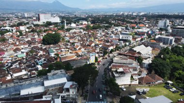 20 Eylül 2024 'te Malang, Endonezya' da, yemyeşil ağaçların arasına yerleşmiş binalar bulunan bir şehir bölgesinin insansız hava aracı görüntüsü. Şehir manzarası gelişim ve yeşillik dengesini sergiliyor ve bölgenin cazibesini artırıyor..