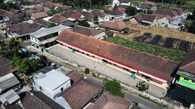 20 Eylül 2024 'te Malang, Endonezya' da, yemyeşil ağaçların arasına yerleşmiş binalar bulunan bir şehir bölgesinin insansız hava aracı görüntüsü. Şehir manzarası gelişim ve yeşillik dengesini sergiliyor ve bölgenin cazibesini artırıyor..