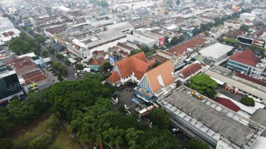 20 Eylül 2024 'te Malang, Endonezya' da, yemyeşil ağaçların arasına yerleşmiş binalar bulunan bir şehir bölgesinin insansız hava aracı görüntüsü. Şehir manzarası gelişim ve yeşillik dengesini sergiliyor ve bölgenin cazibesini artırıyor..