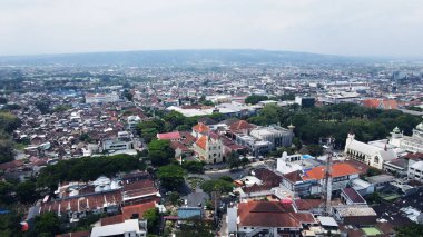 20 Eylül 2024 'te Malang, Endonezya' da, yemyeşil ağaçların arasına yerleşmiş binalar bulunan bir şehir bölgesinin insansız hava aracı görüntüsü. Şehir manzarası gelişim ve yeşillik dengesini sergiliyor ve bölgenin cazibesini artırıyor..