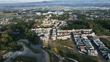 20 Eylül 2024 'te Malang, Endonezya' da, yemyeşil ağaçların arasına yerleşmiş binalar bulunan bir şehir bölgesinin insansız hava aracı görüntüsü. Şehir manzarası gelişim ve yeşillik dengesini sergiliyor ve bölgenin cazibesini artırıyor..