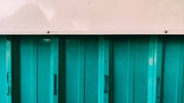 Üzerinde beyaz aksanlar olan yeşil metal bir duvar.