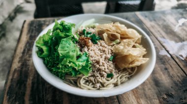 Bir kase tavuk, sebze ve kızarmış hamur tatlısı.