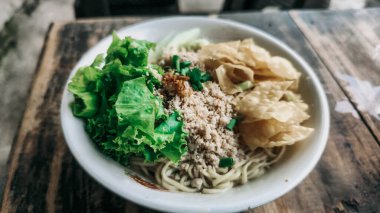 Bir kase tavuk, sebze ve kızarmış hamur tatlısı.