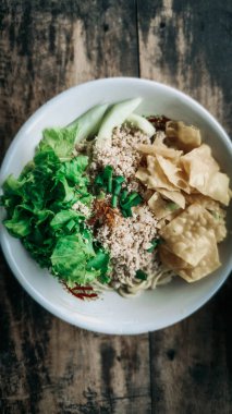 Bir kase tavuk, sebze ve kızarmış hamur tatlısı.