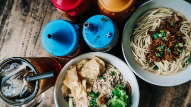 Bir porsiyon cwie mie ve buzlu çay ve soslu tavuklu noodle..