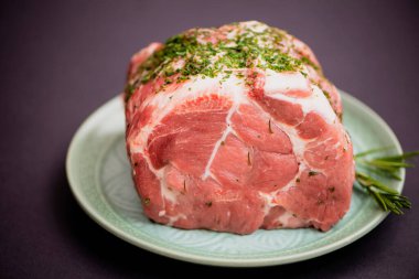 Fırında kızarması için baharatlı büyük bir parça çiğ domuz eti.