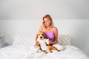 Mutlu bir kadın. 50 yaşında. Sabahları ciddi köpeğine sarılıyor.