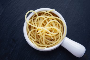 Koyu arkaplanda bir kasede yumurta makarna.