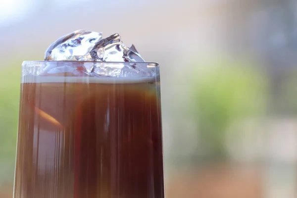 Iced coffee in glass cup or coffee latte on blurred background