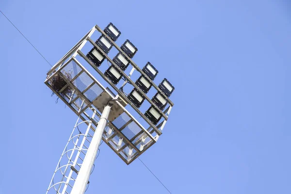 青い空の背景にスポットライトのシルエット スタジアム照明用ランプ — ストック写真