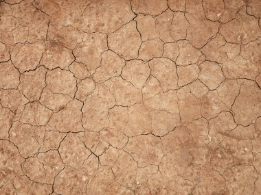 Zemin, kuraklık ve ölüm kavramına sahip arka plan veya grafik tasarımı için üst görünümde çatlaklar var..
