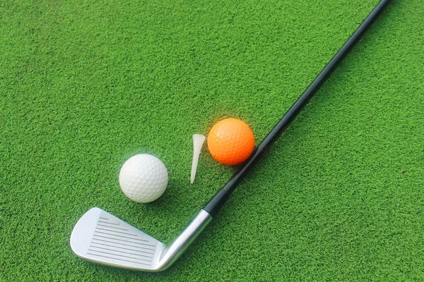 Golf balls and golf clubs as well as equipment used to play golf on green grass in a beautiful golf course. Sports that people around the world play during the holidays for health.