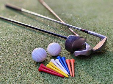 Golf ekipmanları yeşil çimlerin üzerinde. Grafik tasarımı için en üstteki golf topları, golf sopaları ve golf sopaları. Dünyanın dört bir yanındaki insanların sağlık için yaptıkları sporlar..