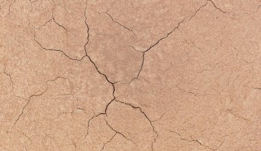 Zemin, kuraklık ve ölüm kavramına sahip arka plan veya grafik tasarımı için üst görünümde çatlaklar var..