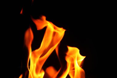 Grafik tasarımı ya da duvar kağıdı için yanan alevleri siyah arkaplanda kapat. Kırmızı ve sarı, ısı enerjisi gece boyunca yakıtı ateşliyor. Yemek pişirmek için kullanılan soyut ateş..