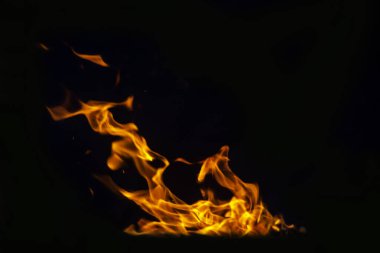 Grafik tasarımı ya da duvar kağıdı için yanan alevleri siyah arkaplanda kapat. Kırmızı ve sarı, ısı enerjisi gece boyunca yakıtı ateşliyor. Yemek pişirmek için kullanılan soyut ateş..