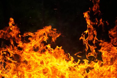 Grafik tasarımı ya da duvar kağıdı için yanan alevleri siyah arkaplanda kapat. Kırmızı ve sarı, ısı enerjisi gece boyunca yakıtı ateşliyor. Yemek pişirmek için kullanılan soyut ateş..