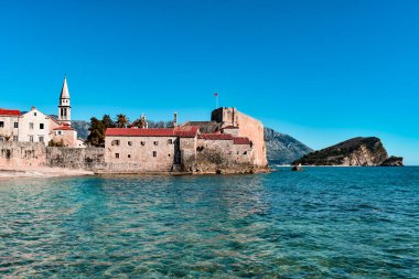 Güzel sahil ve Karadağ 'ın eski Budva kenti. Adriyatik deniz suyu, mavi gökyüzü.