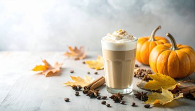 Balkabağı aromalı buzlu kahve. Soğuk köpük, tarçın, sonbahar yaprakları, ahşap masa..  