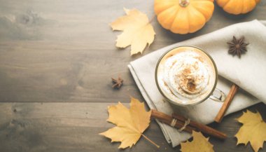 Balkabağı aromalı buzlu kahve. Soğuk köpük, tarçın, sonbahar yaprakları, ahşap masa..