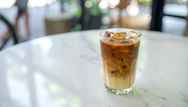  Kremalı buzlu kahve, espresso, süt, bardakta vanilya şurubu, katmanlı buz, karamelli çiseleme, mermer masa, yumuşak bokeh, kafe tarzı..  