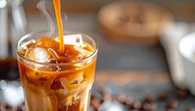 Buzlu kahvenin üzerine erimiş karamel şelalesi, parlak viskozite ve buhar kontrastı 