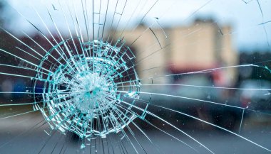 Film kırıkları ve şehir soyutu olan parçalanmış güvenlik camları. 