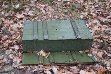 Green empty military box in the forest.