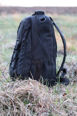 Black backpack on the background of nature.