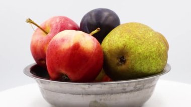Demir bir kasede elmalar ve armutlar sırayla..