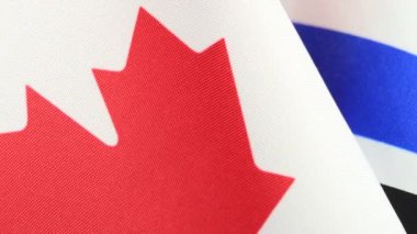 Kanada ve İsrail bayrakları siyah bir arkaplanda birlikte dönüyor..