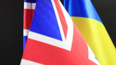 İngiliz ve Ukrayna bayrakları birlikte dönerek, ulusal renklerini vurguluyor.