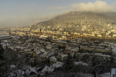 Heidelberg sokaklarında kar ve nehir manzarasıyla yürüyorum.